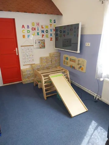 Herna s dřevěnou klouzačkou a písmeny na stěně