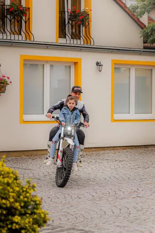 Motorka s dítětem před budovou centra