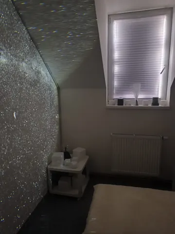 Třpytivá projekce hvězd v senzorické místnosti s odpočinkovým lehátkem